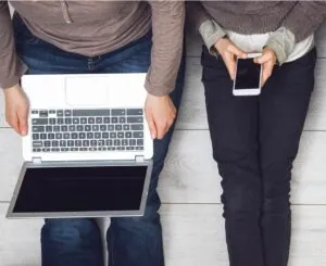 Adicción a la tecnología - Hombre con laptop, mujer con celular