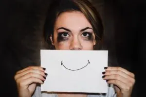 Salud mental - Mujer sosteniendo dibujo de una sonrisa