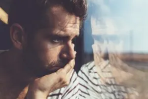 Dependencia emocional hombre mirando por la ventana