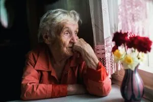 Depresión en la tercera edad - Anciana mirando la ventana