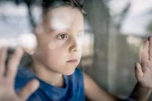 Duelo infantil - Niño mirando a través de la ventana