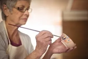 Tercera edad y psicología Mujer pintando taza
