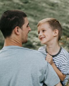 Asperger - Niño sonríe en brazos del padre