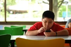 Obesidad infantil niño solo en el colegio