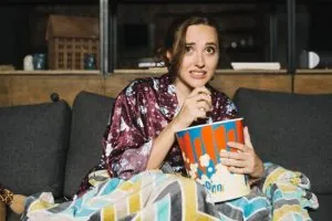 Mujer asustada mira TV