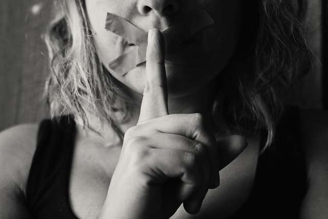 nujer enferma pidiendo silencio